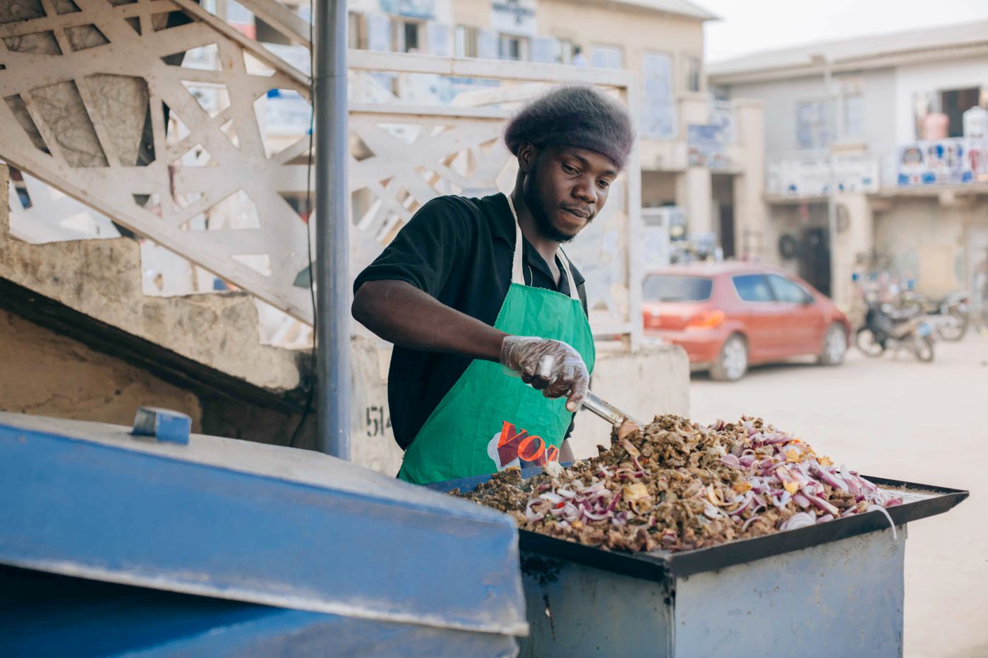 A street-food merchant cooking at a griddle in Lagos, Nigeria
